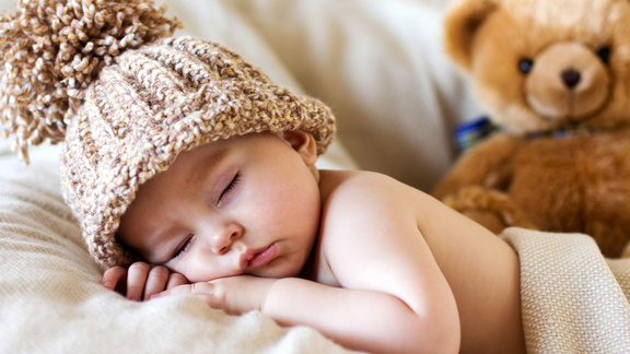 Baby mit Strickmütze schlafend