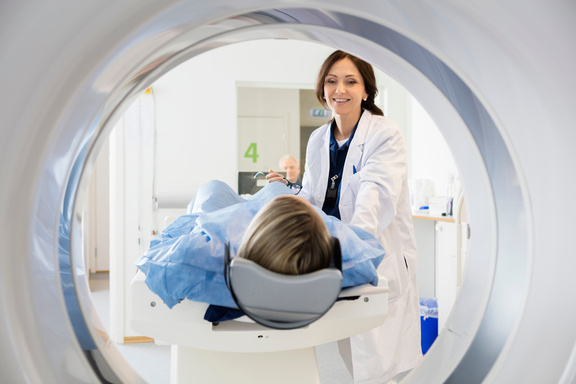 Ärztin hilft Patientin in Röhre
